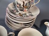 many cups and saucers sitting on a glass table