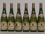 six bottles of wine are lined up in a row on a table