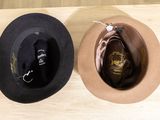 two hats that are sitting on a wooden table
