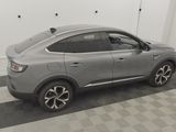 a grey car parked in a garage with a checkered floor