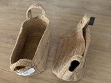 une paire de pantoufles en jute naturel posées sur un parquet, avec une étiquette de prix