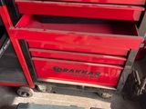 Deux caisses à outils rouges sont posées l'une à côté de l'autre dans un garage
