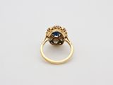 a close up of a gold ring with a blue stone