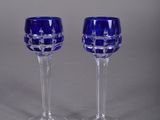 pair of blue glass wine glasses on a grey background
