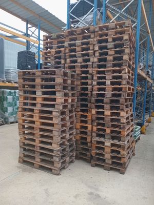 several stacks of wooden pallets stacked on top of each other in a warehouse