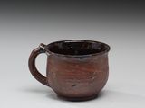 une tasse marron posée sur une table