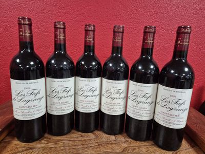 six bottles of red wine are lined up on a barrel