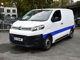 a white van with blue stripes parked in a parking lot