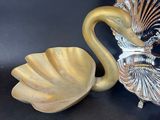 a small mirror and a gold plate with a swan on it