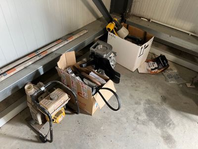 un garage où s'entassent de nombreux cartons et outils par terre
