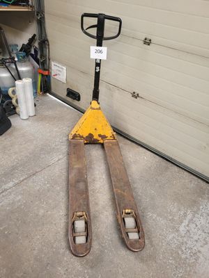 a forklift sitting in front of a garage door