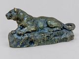 statue d'un chien allongé sur un rocher, posée sur un fond blanc