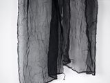 a black scarf hanging on a white wall
