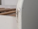 a close up of a white bed with a wooden frame