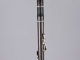 a close up of a silver and black clarinet on a clear surface