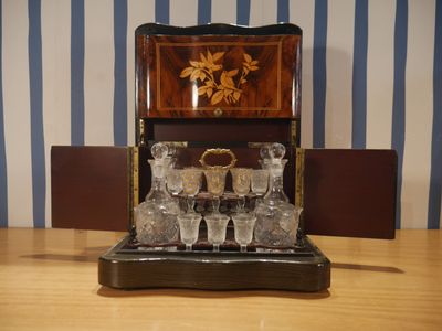 une table en bois sur laquelle sont posés des verres et une boîte en bois