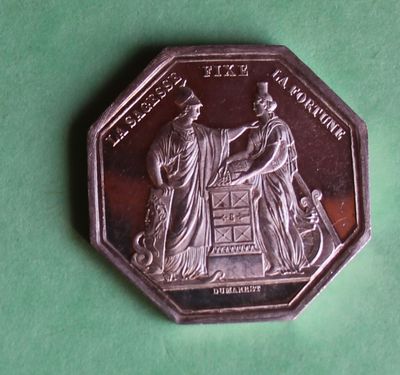 a silver coin with a picture of a man and woman on it