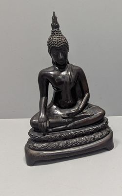 statue d'un Bouddha assis sur un rocher, sur un fond blanc