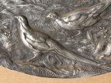 a silver plate with birds on it sitting on a table