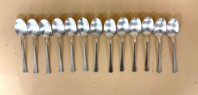 six cuillères en argent alignées en rang sur une table