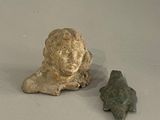 une petite statue représentant une femme et une flèche en pierre