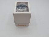 a small white box with a silver watch inside of it