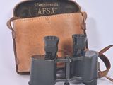 an old pair of binoculars sitting on top of a brown bag