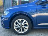 the front end of a blue volkswagen golf parked in front of a building