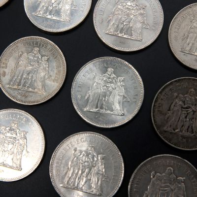 a lot of silver coins that are on a table