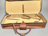 a brown suitcase that is open on a table