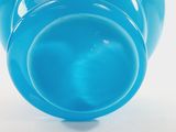 underside view of a blue vase on a white background