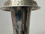 a silver vase with a silver lid on a table