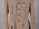 un uniforme militaire sur un mannequin, devant un fond gris
