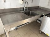 a stainless steel sink in a kitchen with a stainless steel counter top