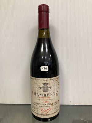 une bouteille de vin posée sur une table, à côté d'un verre de vin
