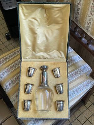 une photo d'un service d'argenterie dans un coffret posé sur une chaise