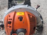 an orange and black chainsaw sitting on top of a gravel road