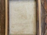 a close up of a picture frame on a wall with a tag on it