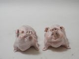 two small pig figurines sitting on a table