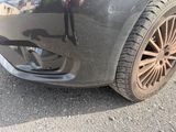 un gros plan sur le pare-chocs avant et le pneu d'une voiture
