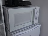 two microwaves stacked on top of each other in a kitchen