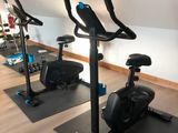 three exercise bikes are lined up in a row in a gym