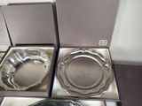 three silver plates in a box on a table