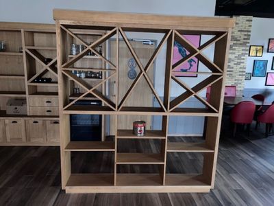 une bibliothèque en bois avec un casier à bouteilles au milieu