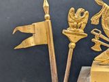 brass figurine of a man with a sword, a book, and other items