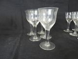 several empty wine glasses are lined up on a black surface
