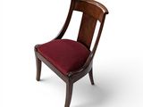 une image représentant une chaise en bois sur laquelle est posé un coussin rouge