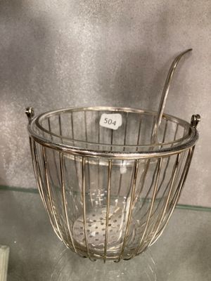un panier en métal posé sur une table, contenant une cuillère