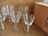 four empty wine glasses sitting on a table next to a box