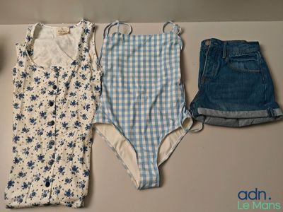 trois vêtements posés sur une table, à côté d'une tasse